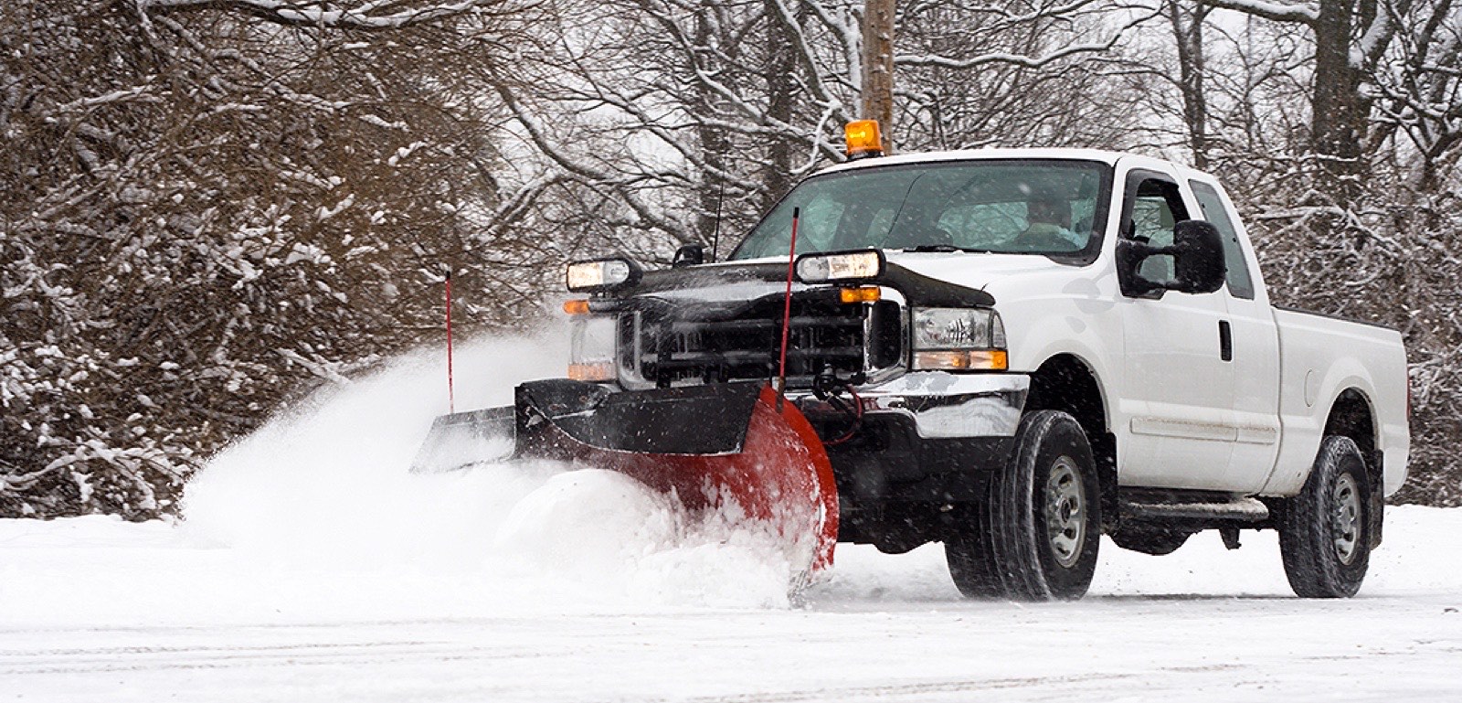Pickup truck with front plow pushing snow